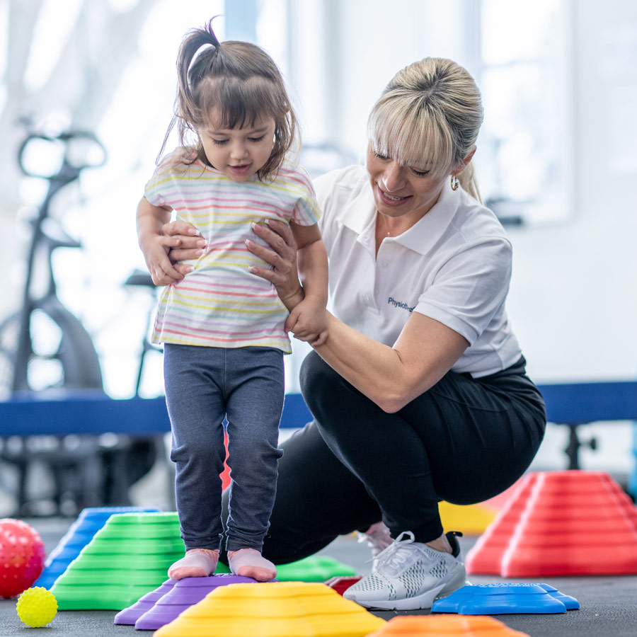 Occupational therapist helps toddler with balance